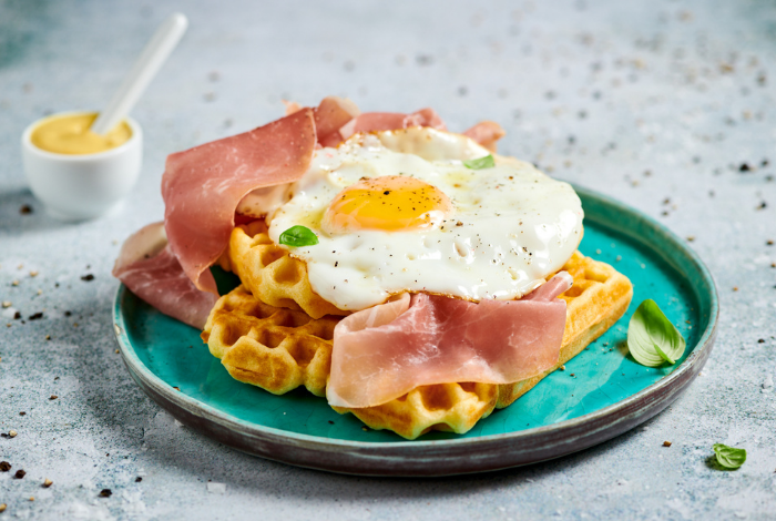 Waffle with eggs benedict, prosciutto and mustard