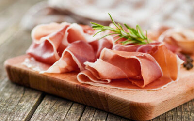 Behind a slice of prosciutto